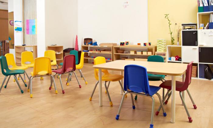 empty rainbow chairs and tables in classroom