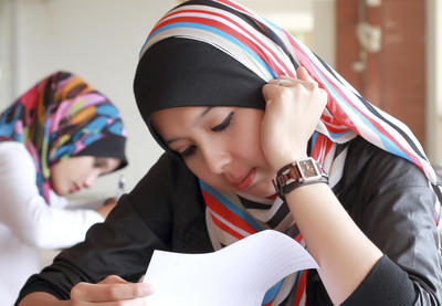A Muslim girl reads at her desk.