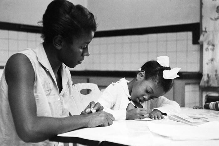 A black teacher instructs a young black student